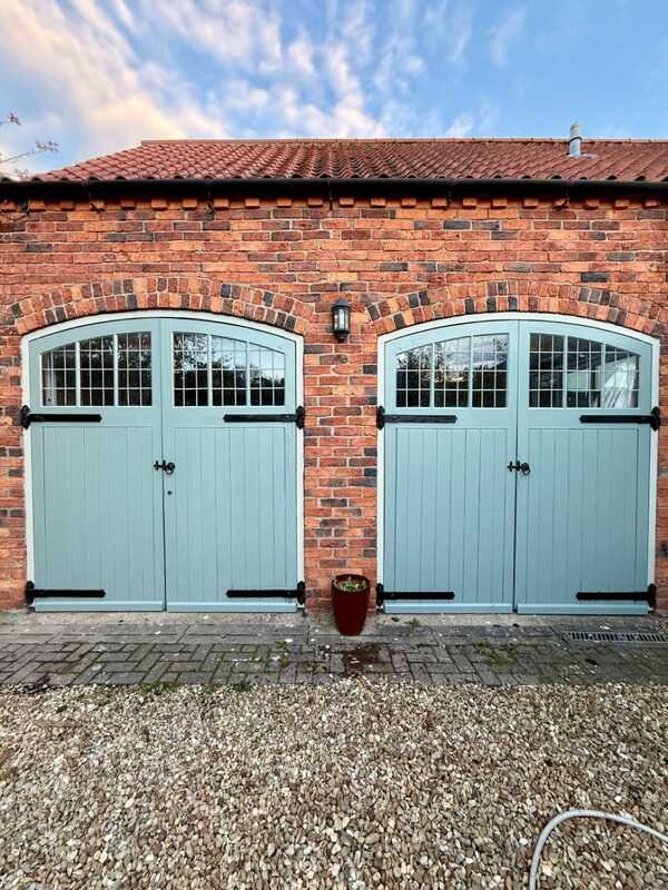Painted blue garden building doors by AA Painting and Decorating
